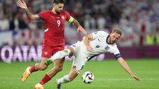 Harry Kane is challenged by Aleksandar Mitrovic of Serbia