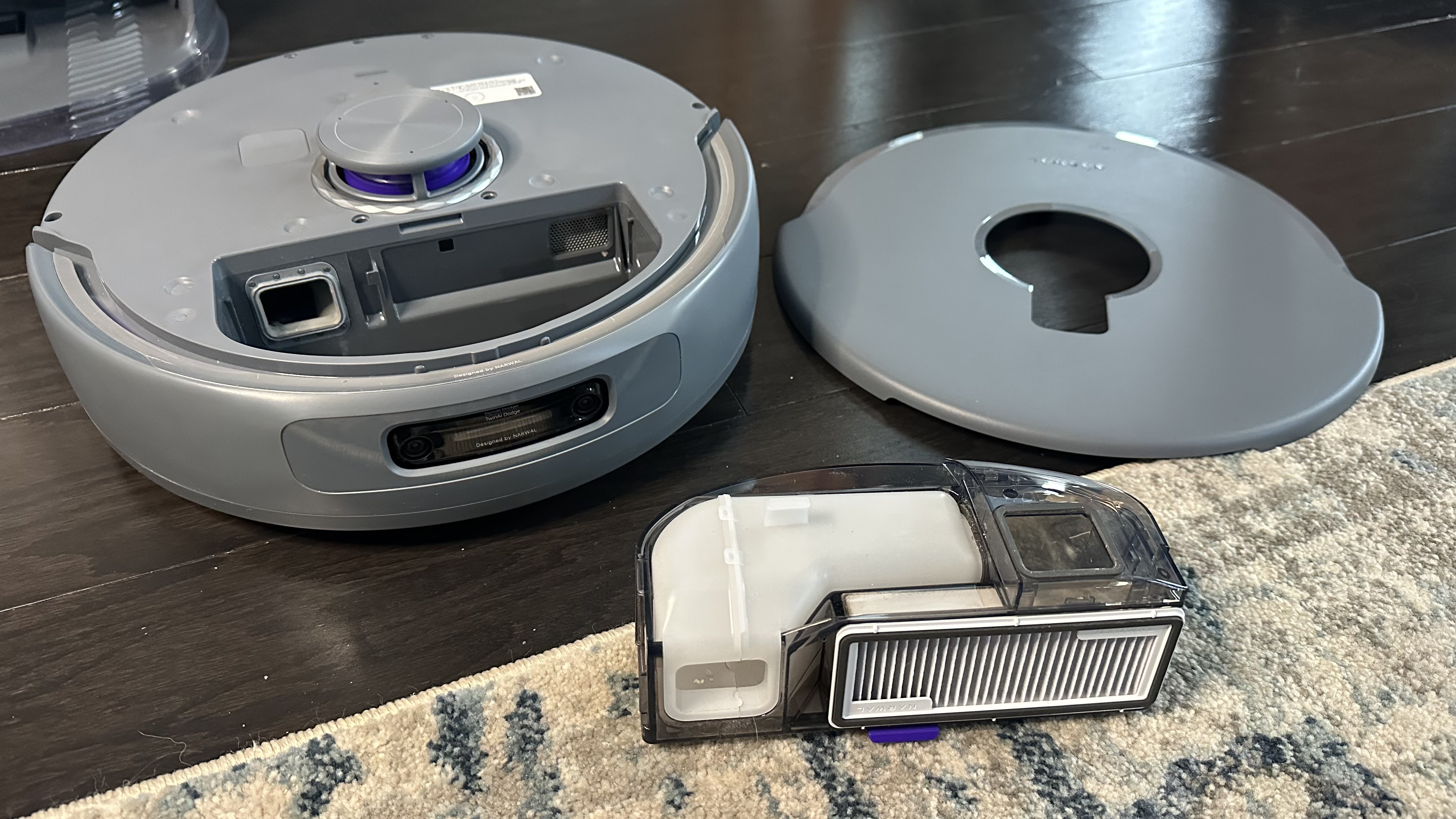 Lid and dust box removed from robot vacuum. Dust box filter and 'wet' waste filter exposed