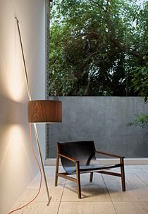 Movable wooden lamp shade next to chair on tiles