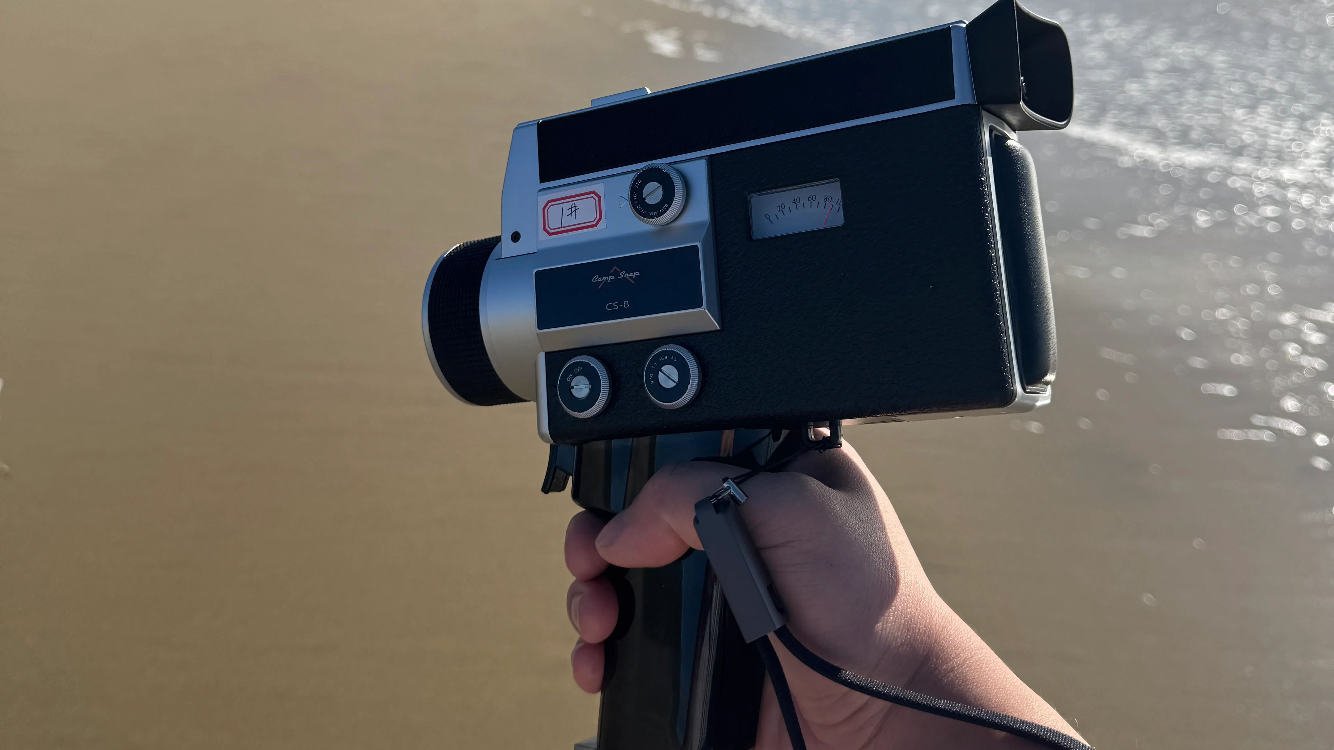 The Camp Snap CS8 held in a person's hand at a beach