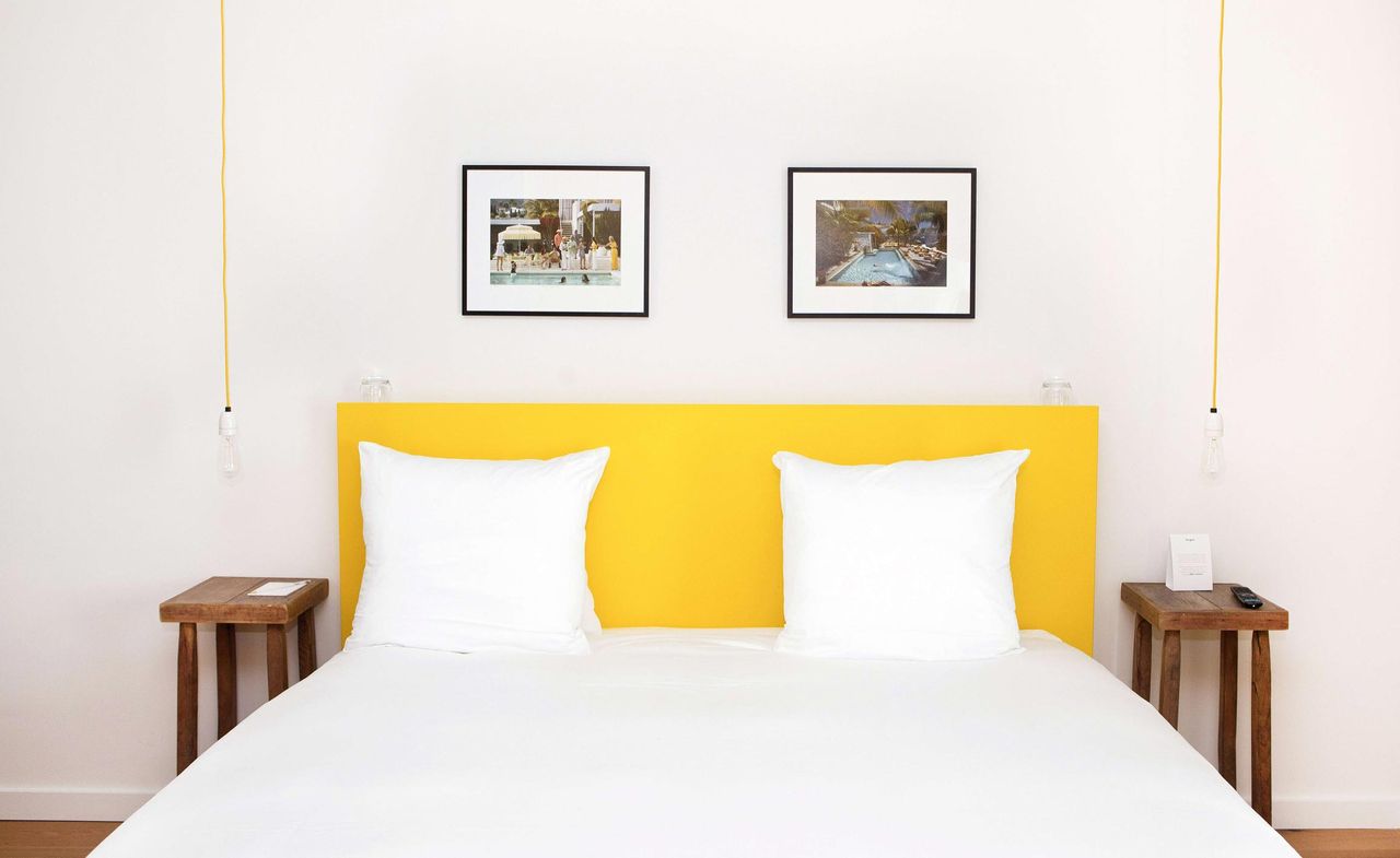 White and yellow linen with wood stool side tables, low hanging lighting fixtures