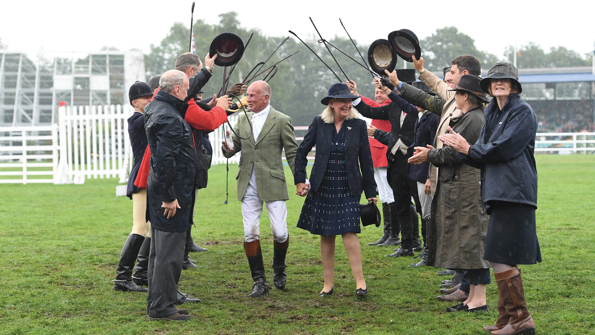 Allister Hood walks through a guard of honour at Royal International Horse Show with his wife in hand