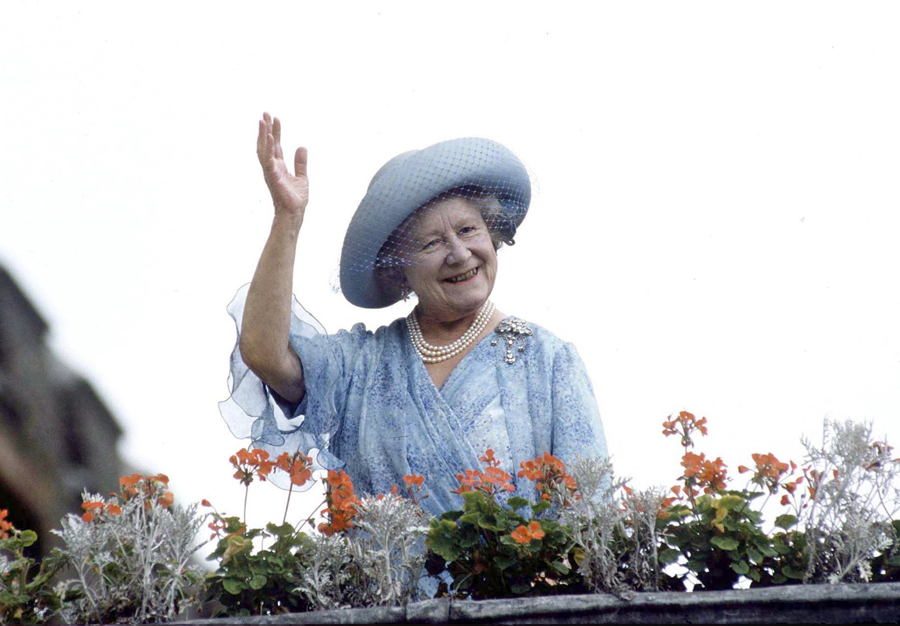 Queen Mother wearing blue and waving from a balcony