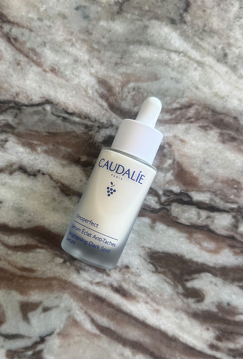 Caudalie vitamin C serum bottle on marble table