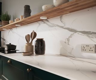 marble veined splashback and worktop in kitchen with wooden shelf above worktop