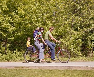 Mom and family on tandem bicycle riding outdoors