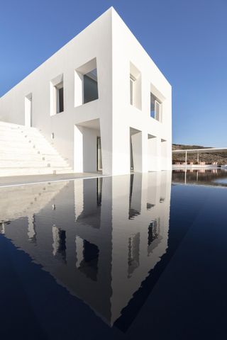 Avlakia House in Greece with a water reflection in front.