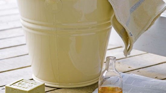 steel bucket with cloth cleaning liquid soap on wooden surface