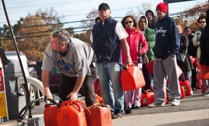 A man fills up jerry cans with gasoline as others wait in line on Nov. 1 in Hazlet township, N.J.