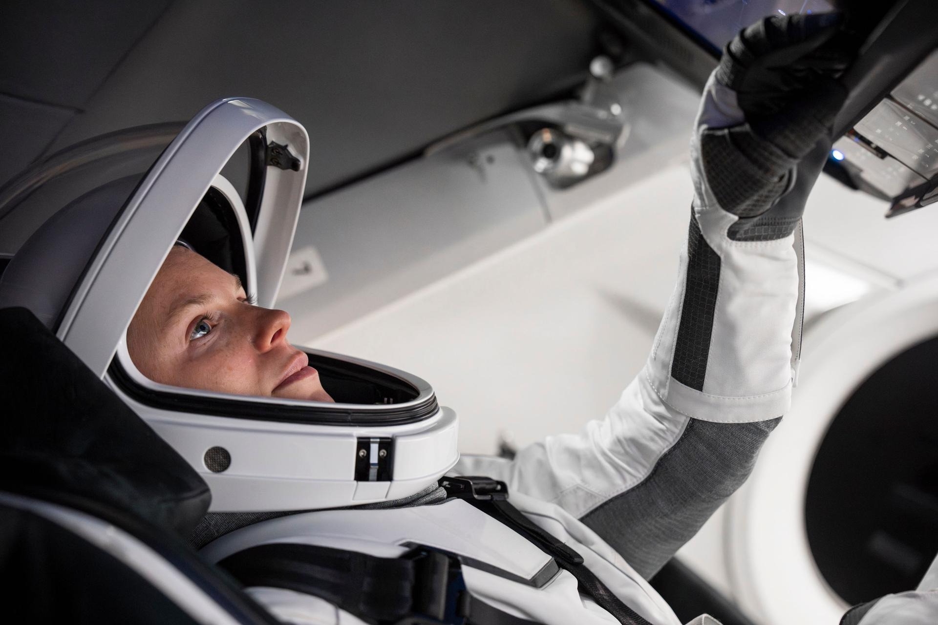 astronauts in white spacesuits pose for portraits
