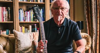 Martin Barre of Jethro Tull photographed at home in front of his bookshelf, with his pristine Gibson ES-330TD