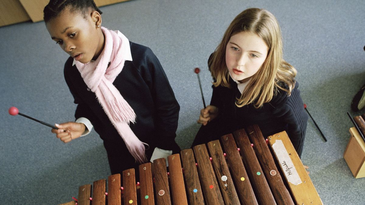 Two young children playing xylophone