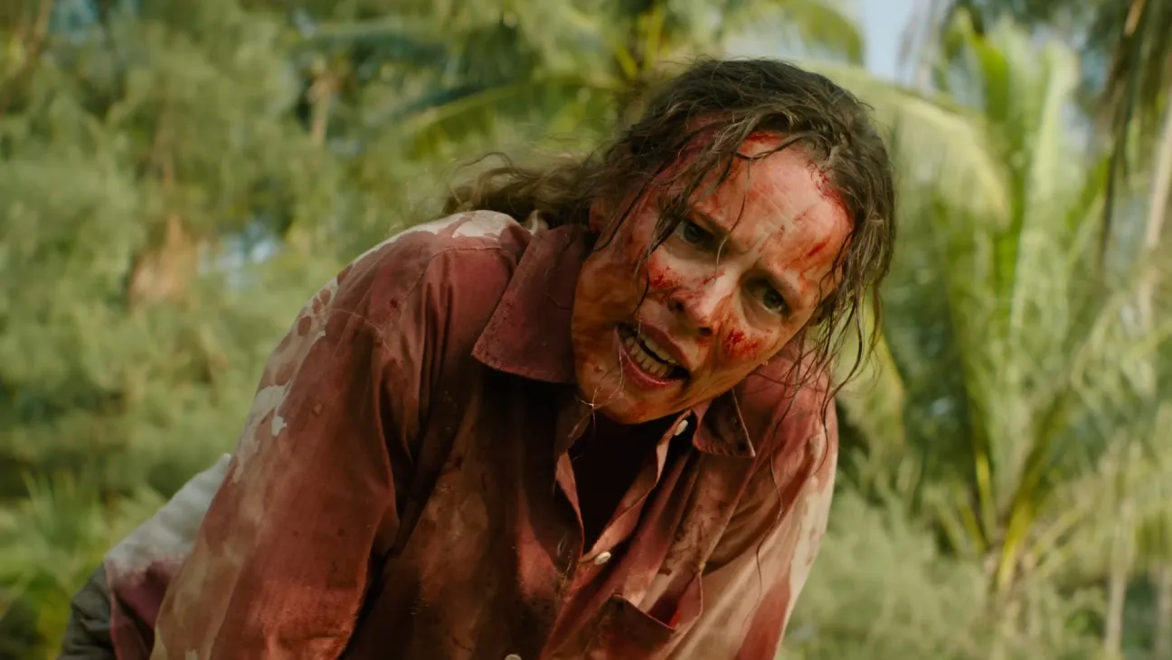 rachel mcadams covered in blood and looking angry surrounded by palm trees on a beach in the survival thriller send help