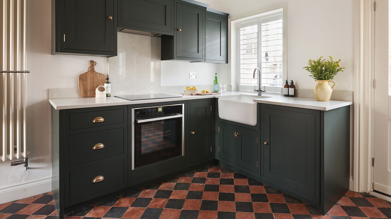 Dark green shaker kitchen with tiled floor