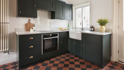 Kitchen with marble worktop and backsplash, grey cabinets, with oven and hob