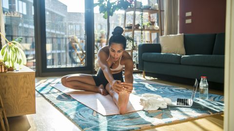 Gaia Yoga and Meditation Online review: A woman takes a yoga class in her living room