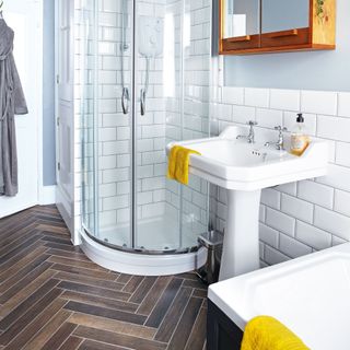 herringbone flooring in bathroom with shower and sink