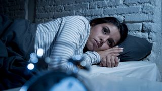 Woman lying awake in bed at night