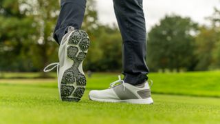 A golfer on their follow-through wearing the Ram golf XT1 men's waterproof golf shoe