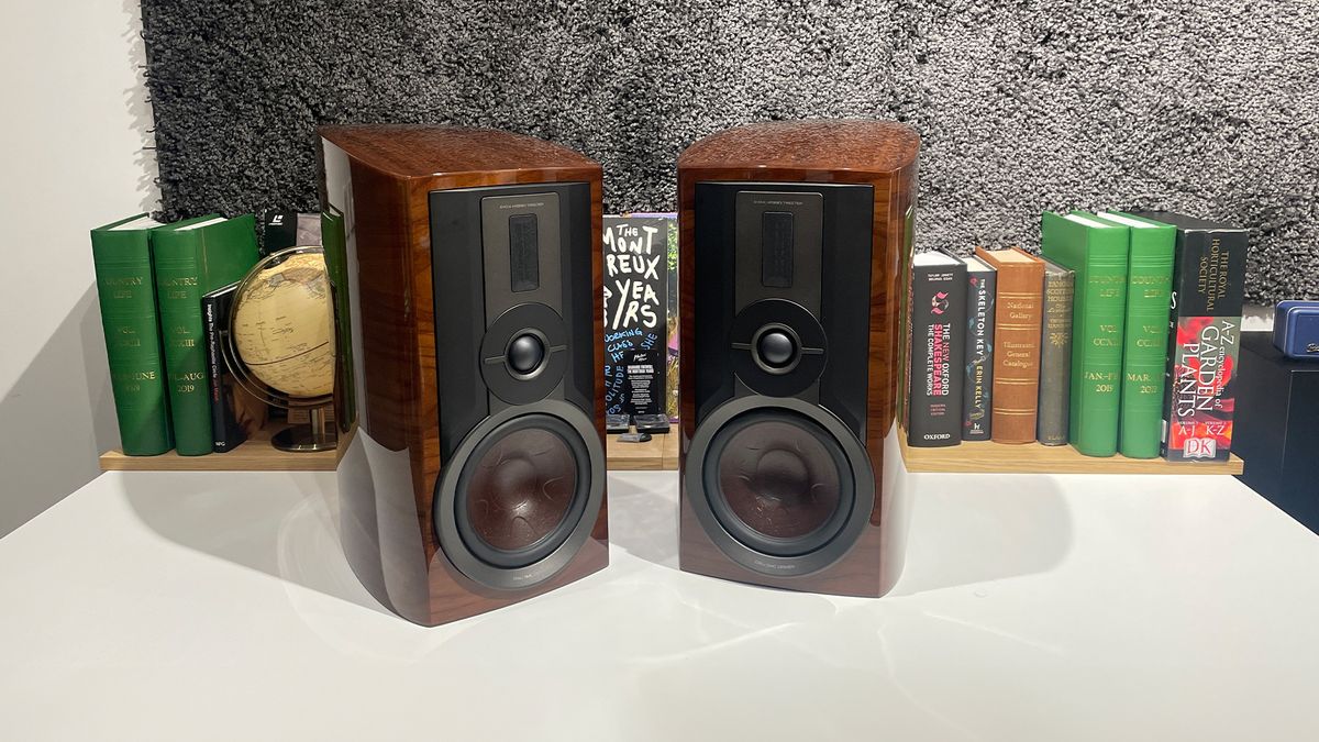 Dali Epikore 3 standmount speakers on white shelf with books behind