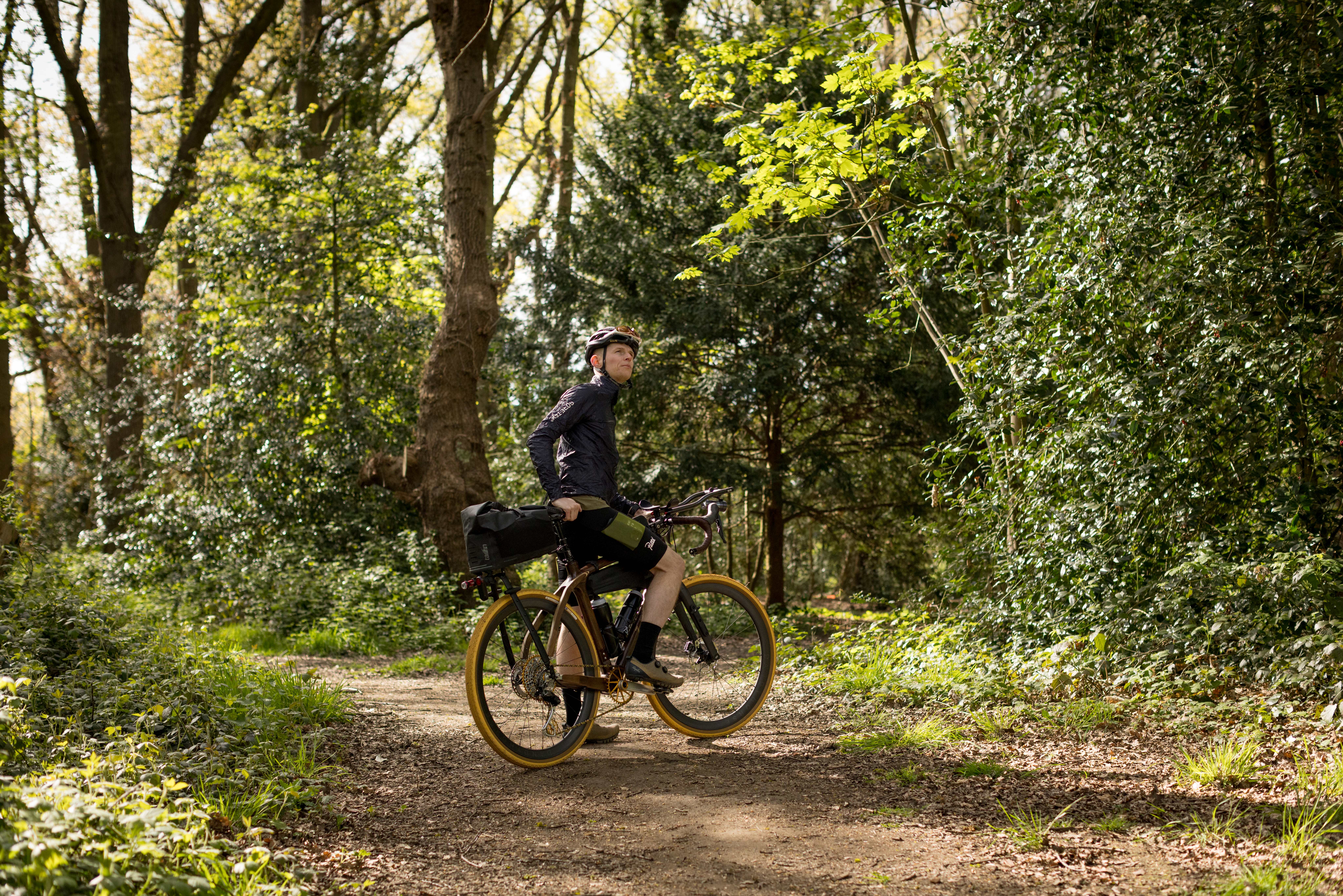 Tom looks up in a woodland on a bike