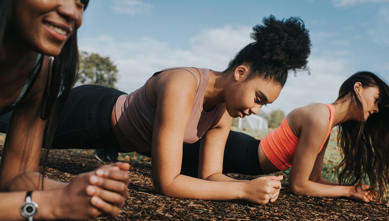 Three woman in a sunny outdoor environment Planking - stock photo