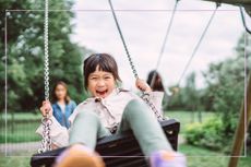 Girl laughing on a swing