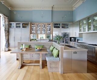 Wood effect kitchen with banquette seating and kitchen island sink