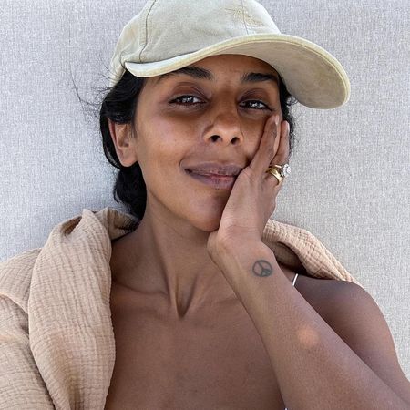 Monikh wearing cap and natural skin possibly with tinted SPF