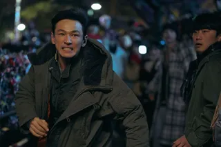 Hwang Jung-min runs past a group of onlookers on a lock bridge, in 'I, The Executioner.'