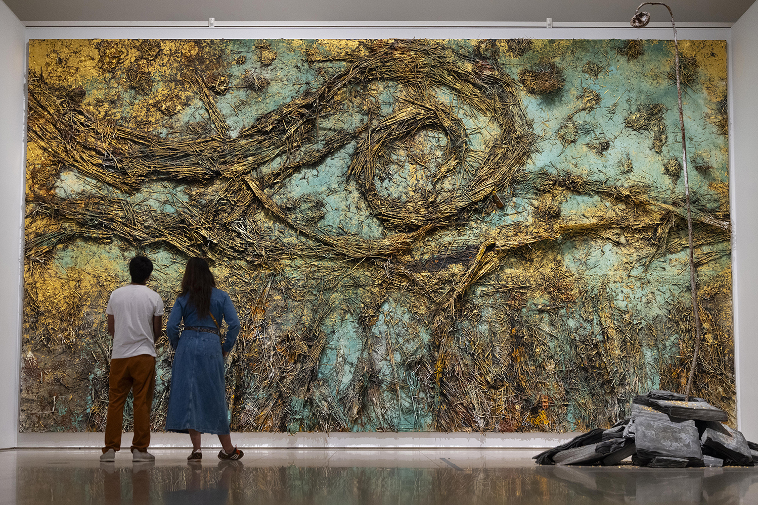 people looking at large textured painting