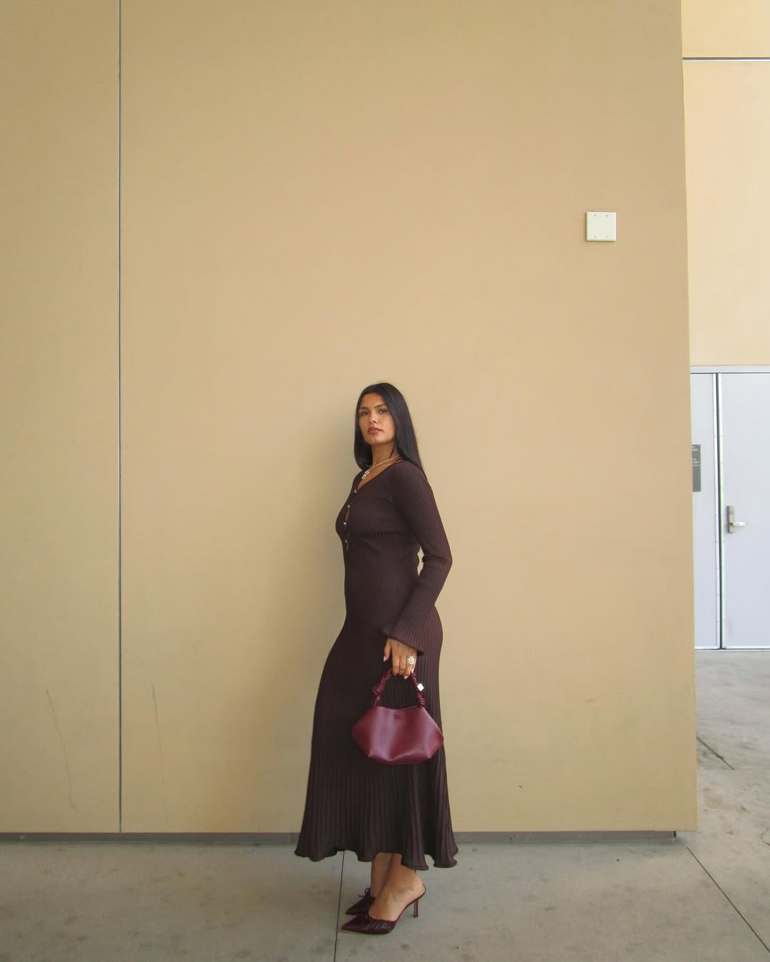 @isabellecoheen wears a chocolate brown knitted dress, mules and burgundy bag