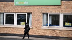 A man walking in front of a Jobcentre Plus