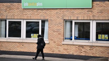 A man walking in front of a Jobcentre Plus