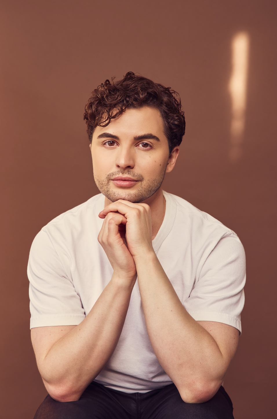 a white man with light brown hair in a white t-shirt