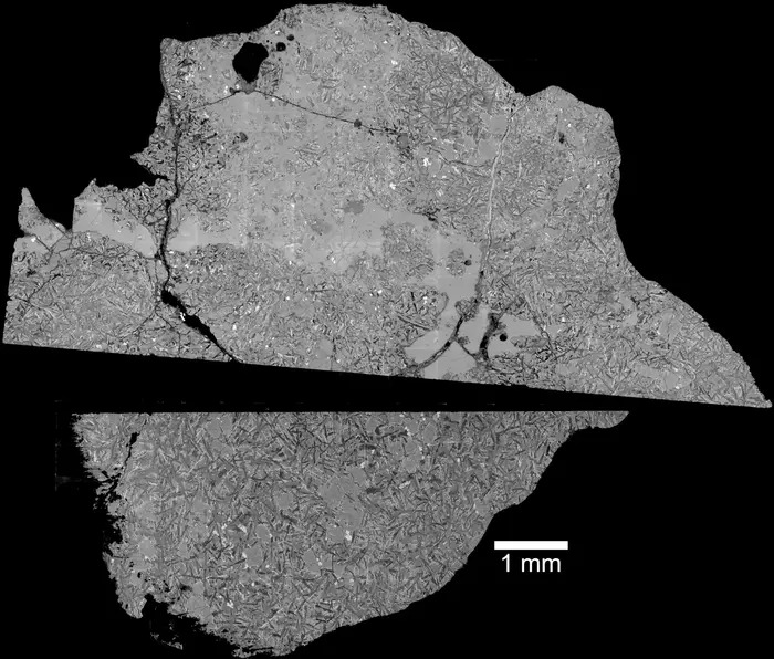 Two halves of a gray moon rock on a black background