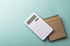white calculator next to brown calendar