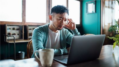 A man stares worriedly at his computer.