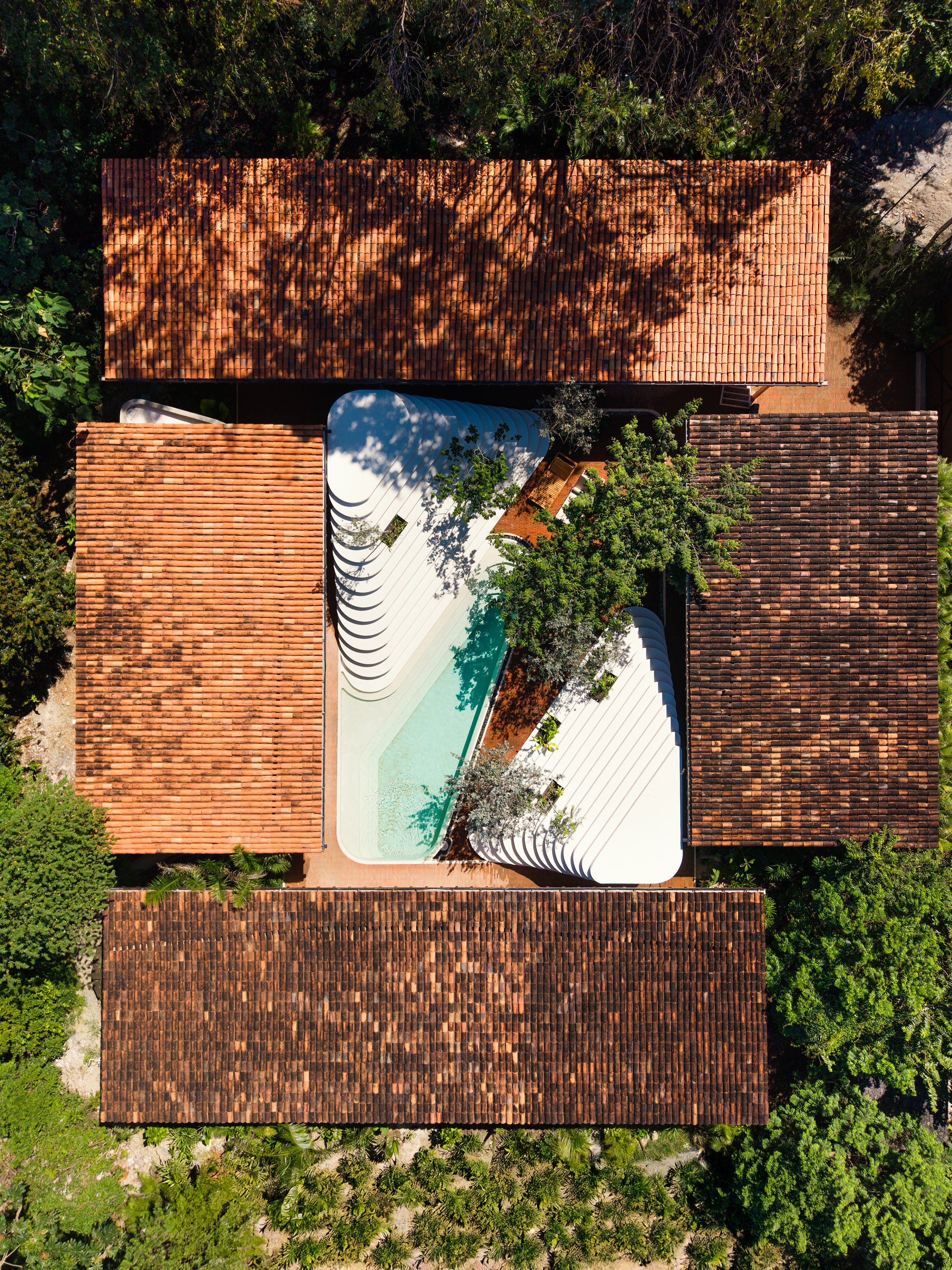 a sculptural Patio house in Costa Rica, textured, low volumes among tropical greenery