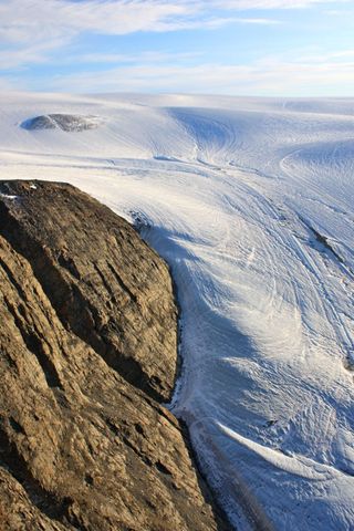 Areal view of the Sverdrup Glacier, a river of ice that flows from the interior of the Devon Island Ice Cap into the ocean. Nunavut, Canada. Flow stripes are clearly visible on the surface of the glacier.