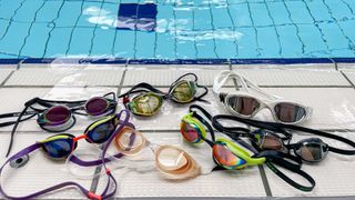 Best swimming goggles, shown laying together next to an indoor swimming pool