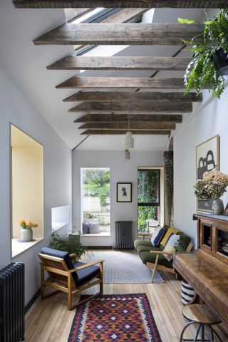 small music and living room with picture windows and exposed beams
