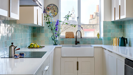 a small galley kitchen with crown molding and blue zellige tiles on the wall and floor