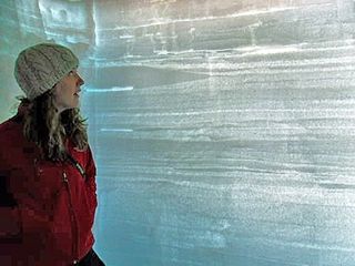 Lead study author Kaitlin Keegan examining surface melt layers in the Greenland ice sheet.
