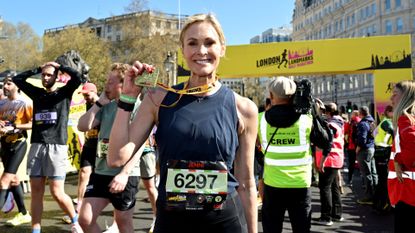 Jenni Falconer holding up medal after running race