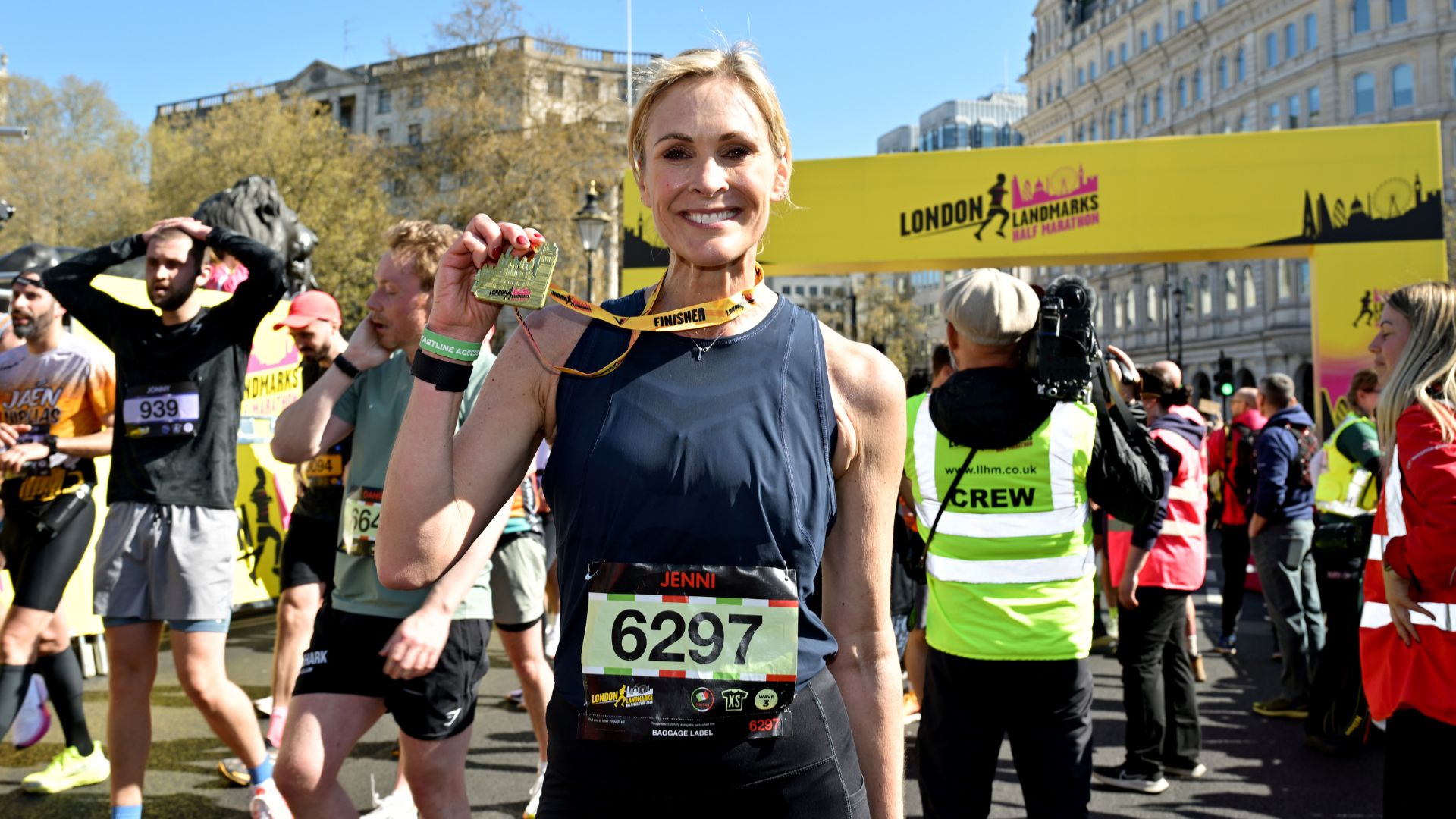 Jenni Falconer holding up medal after running race