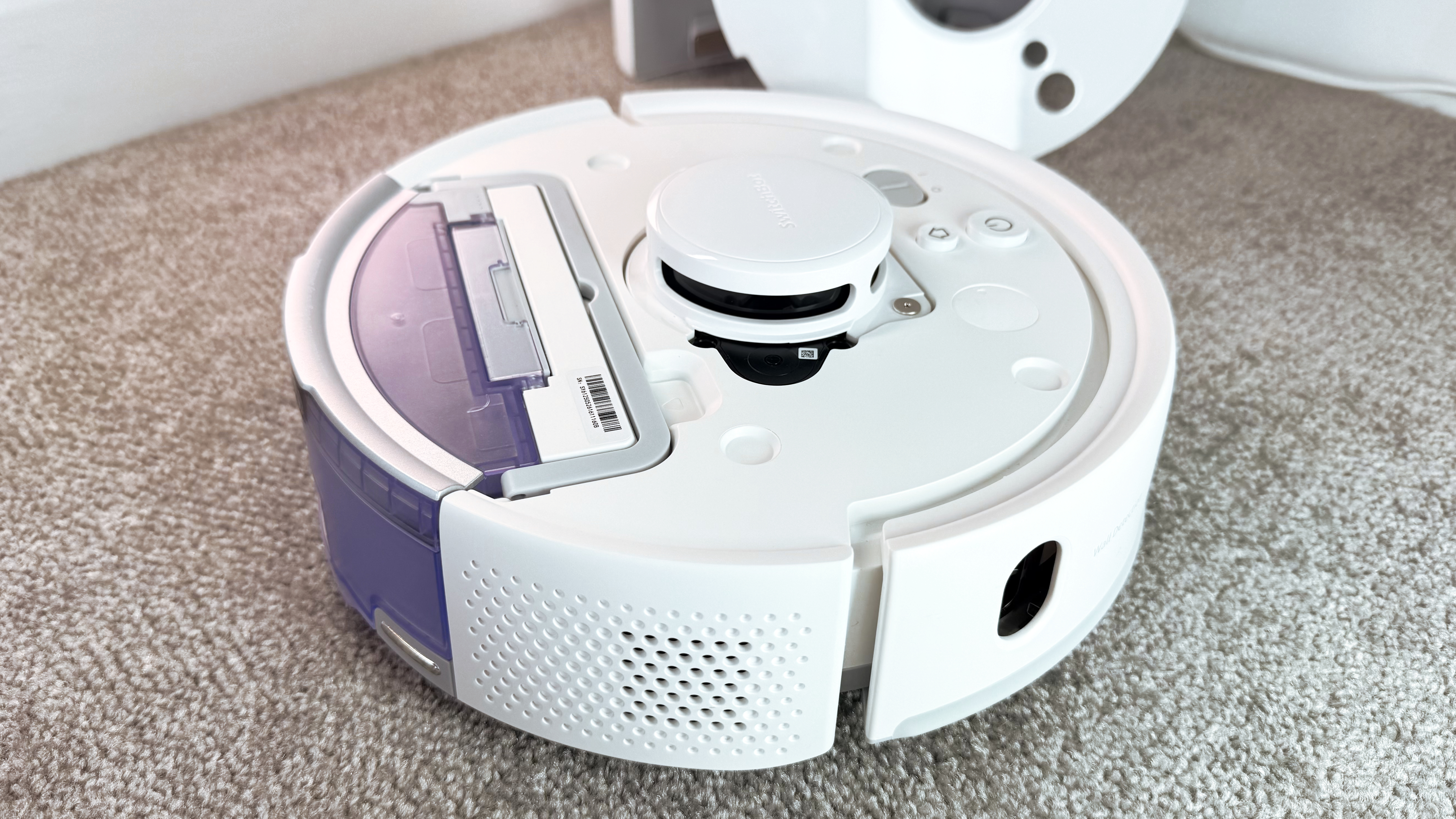 The top panel has been removed from the SwitchBot K11 plus, revealing the master power switch and the top of the dust compartment.