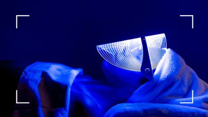 A person receiving blue light therapy for acne as treatment, a woman is lying down on a bed wearing an LED blue mask