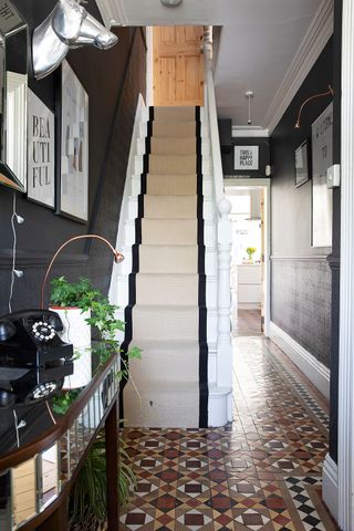 original features of a Victorian terrace with carpet runner up staircase and period floor tiles