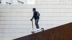 Man riding e-scooter down a ramp